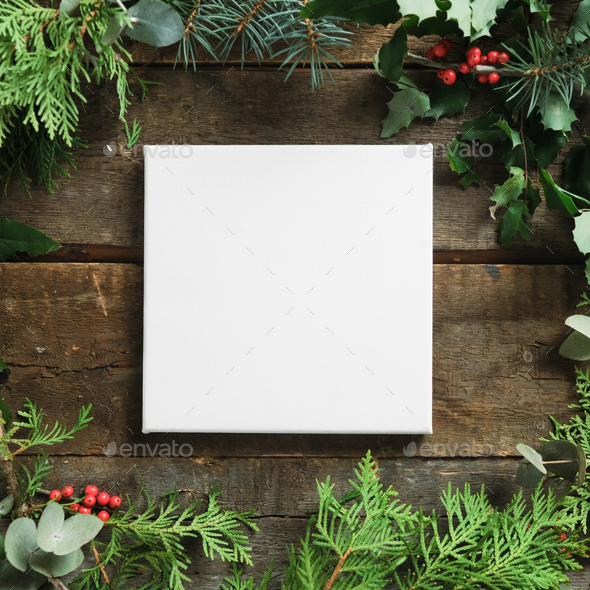 Christmas frame. Blank canvas on wooden background with Christmas greenery